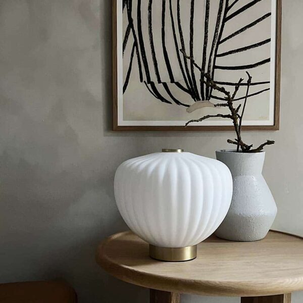 MOma bordlampe i hvidt opalglas med bølget kuppel og børstet messing base. Elegant design med blødt lys og luksuriøs messingfinish – perfekt til ethvert rum