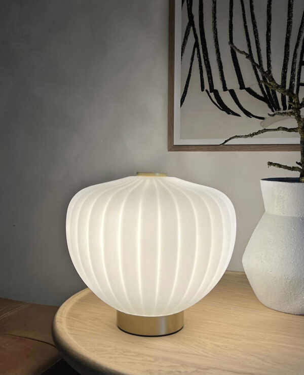 MOma bordlampe i hvidt opalglas med bølget kuppel og børstet messing base. Elegant design med blødt lys og luksuriøs messingfinish – perfekt til ethvert rum