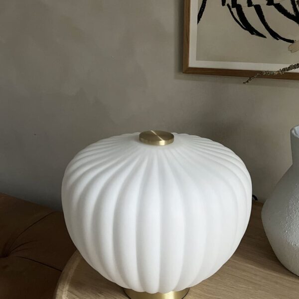 MOma bordlampe i hvidt opalglas med bølget kuppel og børstet messing base. Elegant design med blødt lys og luksuriøs messingfinish – perfekt til ethvert rum
