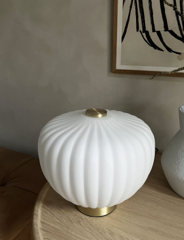 MOma bordlampe i hvidt opalglas med bølget kuppel og børstet messing base. Elegant design med blødt lys og luksuriøs messingfinish – perfekt til ethvert rum
