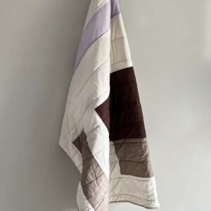 Patch quiltet tæppe i lilla, beige og brune nuancer. 130x170 cm.