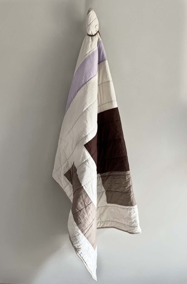 Patch quiltet tæppe i lilla, beige og brune nuancer. 130x170 cm.